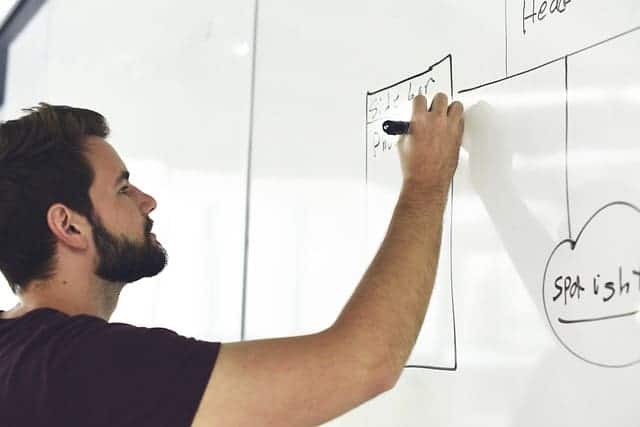 man writing on a white board
